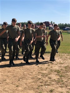 Grupa uczniów biegnie ubrana w mundury wojskowe